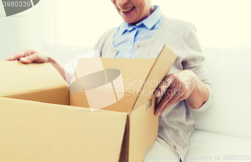 Image of close up of senior woman with parcel box at home