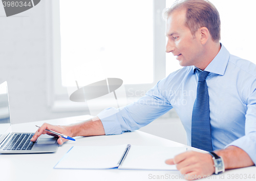 Image of smiling businessman working in office