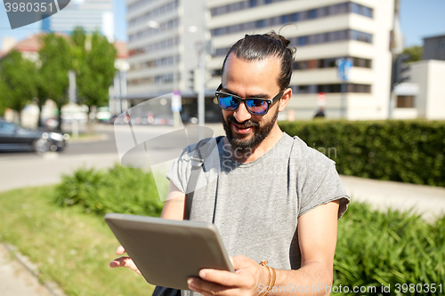 Image of man traveling with backpack and tablet pc in city