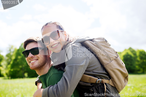 Image of happy couple with backpacks having fun outdoors