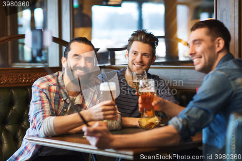 Image of friends taking selfie and drinking beer at bar