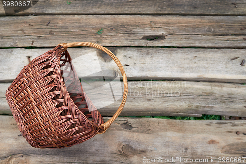 Image of Wicker basket on weathered wooden background