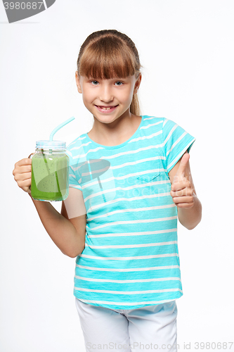 Image of Girl holding jar tumbler mug with green smoothie drink