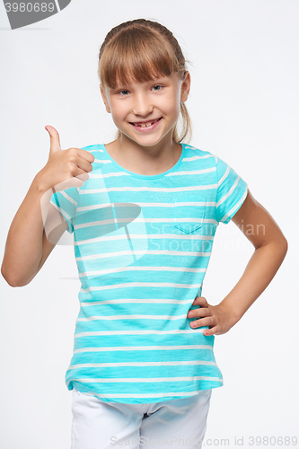 Image of Smiling elementary school age girl showing thumb up