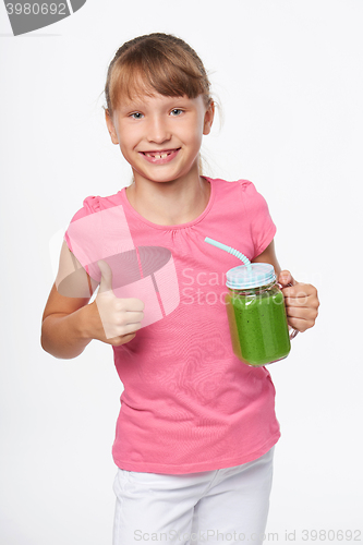 Image of Girl holding jar tumbler mug with green smoothie drink