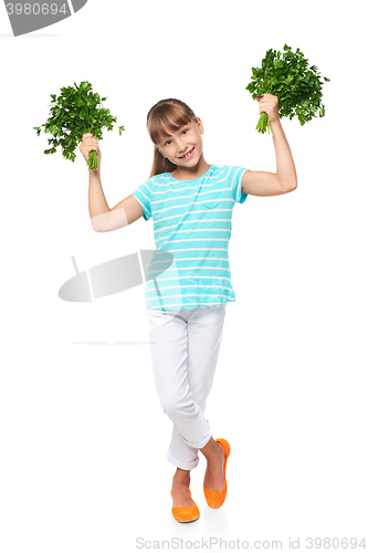 Image of Smiling elementary school age girl showing fresh parsley