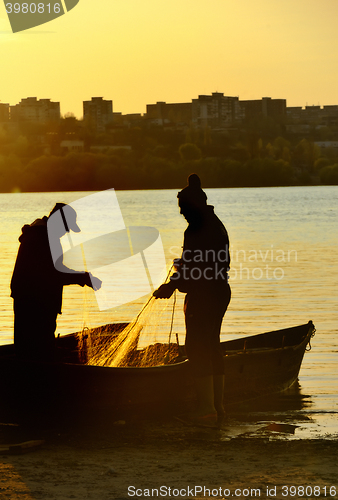 Image of Fishermen silhouette at sunset