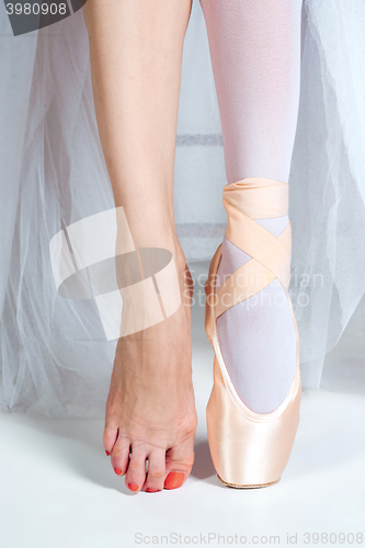 Image of The close-up feet of young ballerina in pointe shoes