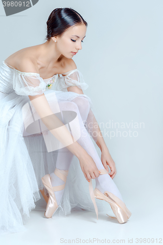 Image of Professional ballerina putting on her ballet shoes