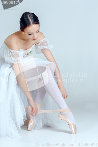 Image of Professional ballerina putting on her ballet shoes