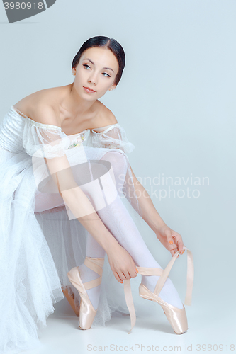Image of Professional ballerina putting on her ballet shoes