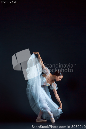 Image of Portrait of the classical ballerina in white dress on black background