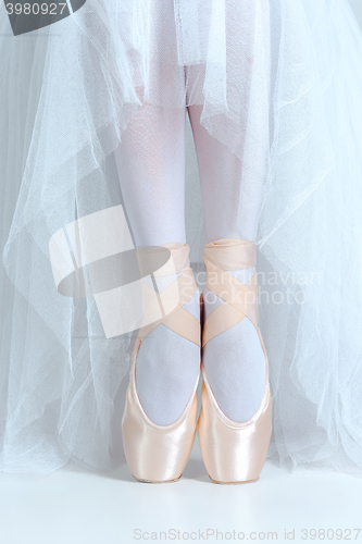 Image of The close-up feet of young ballerina in pointe shoes