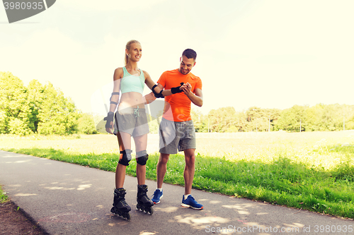 Image of happy couple with roller skates riding outdoors