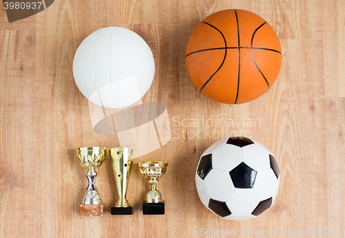 Image of football, basketball, volleyball balls and cups