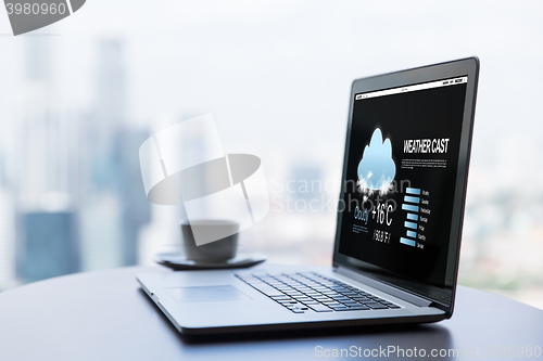 Image of close up of laptop and coffee cup on office table