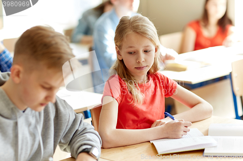 Image of group of students with books writing school test