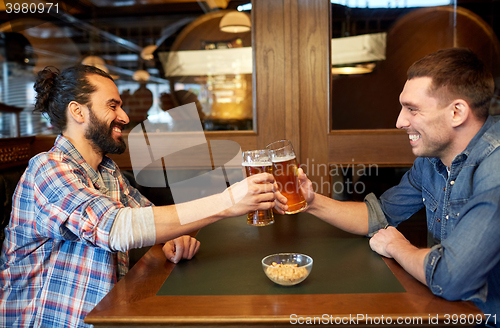 Image of happy male friends drinking beer at bar or pub