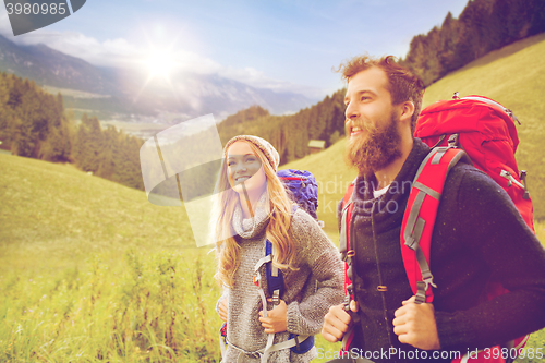 Image of smiling couple with backpacks hiking