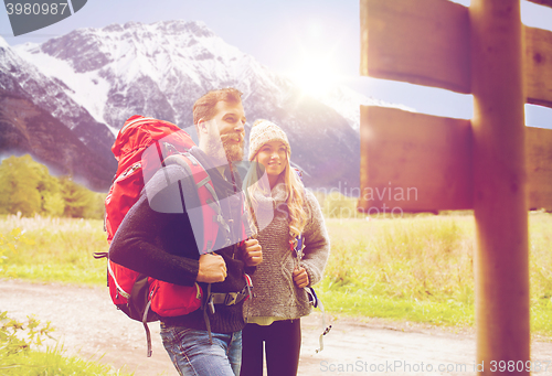 Image of smiling couple with backpacks hiking