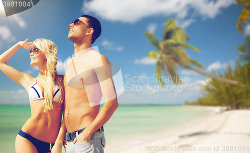 Image of happy couple over exotic tropical beach background