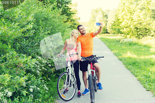 Image of couple with bicycle and smartphone taking selfie