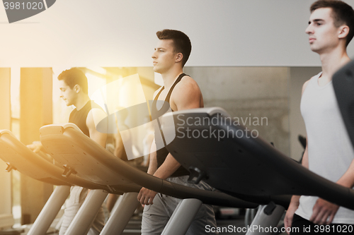 Image of group of men exercising on treadmill in gym