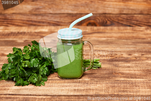 Image of Mug with green smoothie drink and bundle of fresh parsley