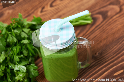 Image of Mug with green smoothie drink and bundle of fresh parsley