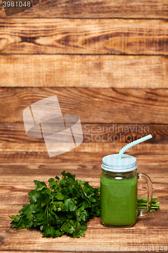 Image of Mug with green smoothie drink and bundle of fresh parsley