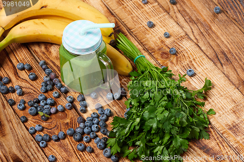 Image of Mug with green smoothie drink and bundle of fresh parsley