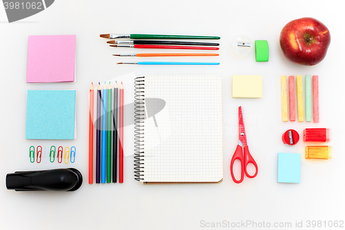 Image of School set with notebooks, pencils, brush, scissors and apple on white background