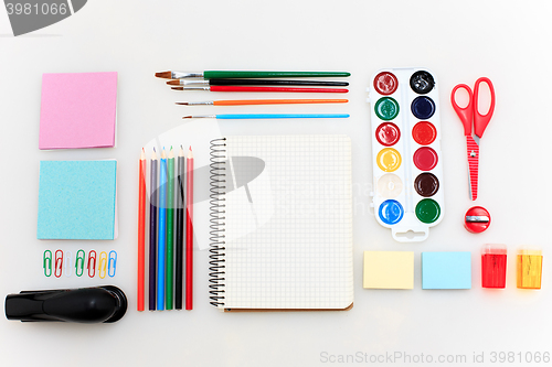 Image of School set with notebooks, pencils, brush, scissors and apple on white background