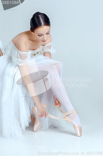 Image of Professional ballerina putting on her ballet shoes