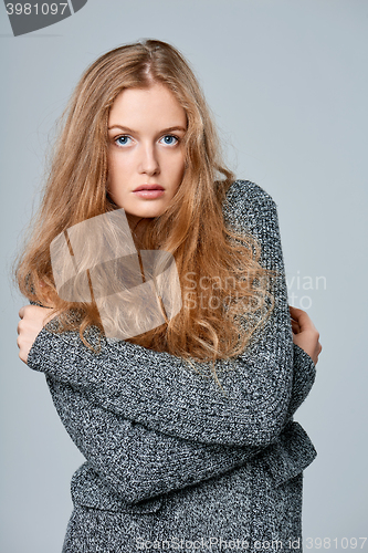 Image of Woman muffling in warm knitted cardigan