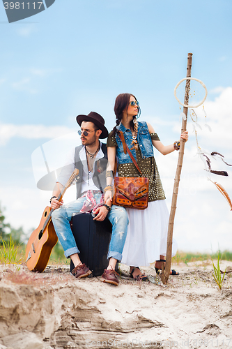 Image of Man and woman as boho hipsters against blue sky