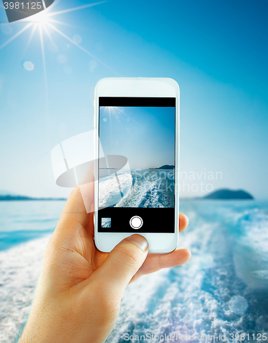 Image of The male hand taking photo of the water