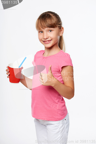 Image of Little child girl holding a drink in disposable paper cup