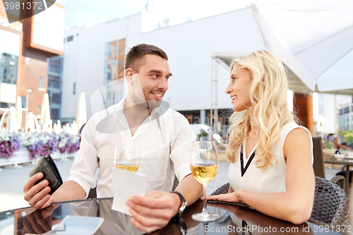 Image of happy couple with wallet paying bill at restaurant