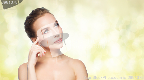 Image of beautiful young woman touching her face