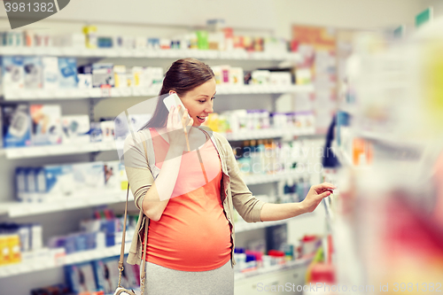 Image of happy pregnant woman with smartphone at pharmacy