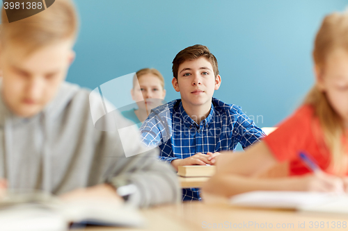 Image of group of students with notebooks at school lesson