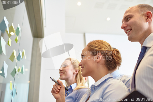 Image of smiling business people with marker and stickers