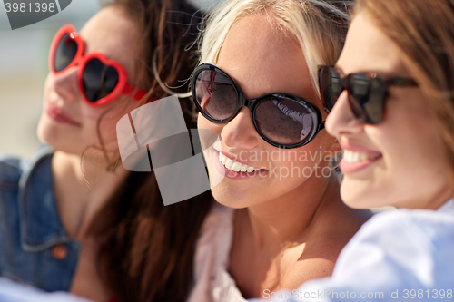 Image of group of smiling women taking selfie on beach