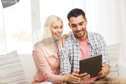 Image of smiling happy couple with tablet pc at home