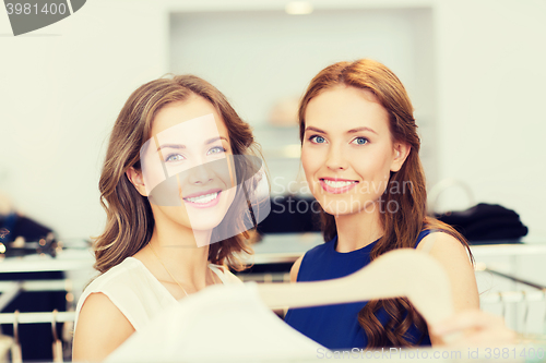 Image of happy women with shopping bags at clothing shop