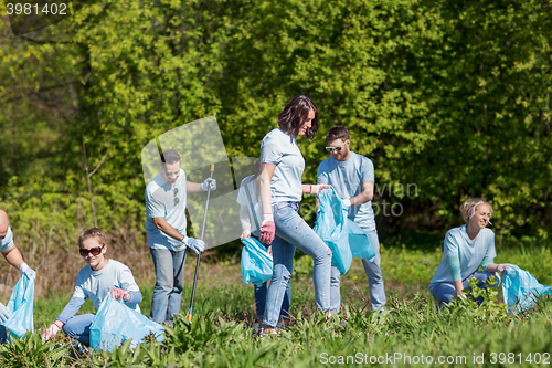 Image of volunteers with garbage bags cleaning park area