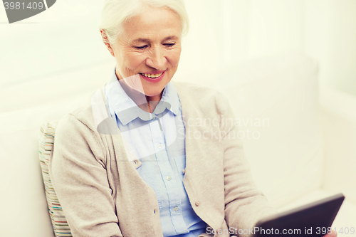 Image of happy senior woman with tablet pc at home