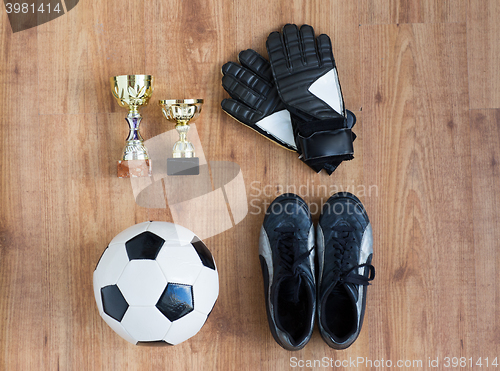 Image of soccer ball, boots, goalkeeper gloves and cups