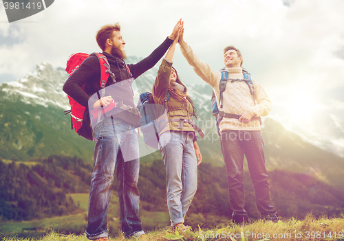 Image of group of smiling friends with backpacks hiking